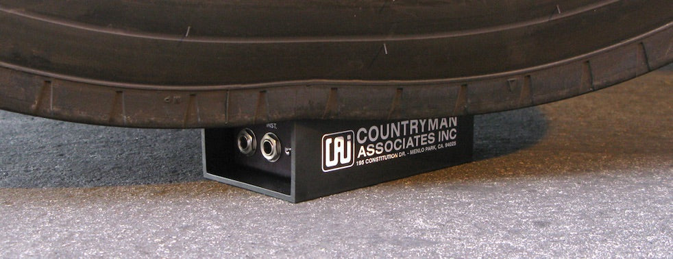Closeup of a Countryman Direct Box underneath a truck tire