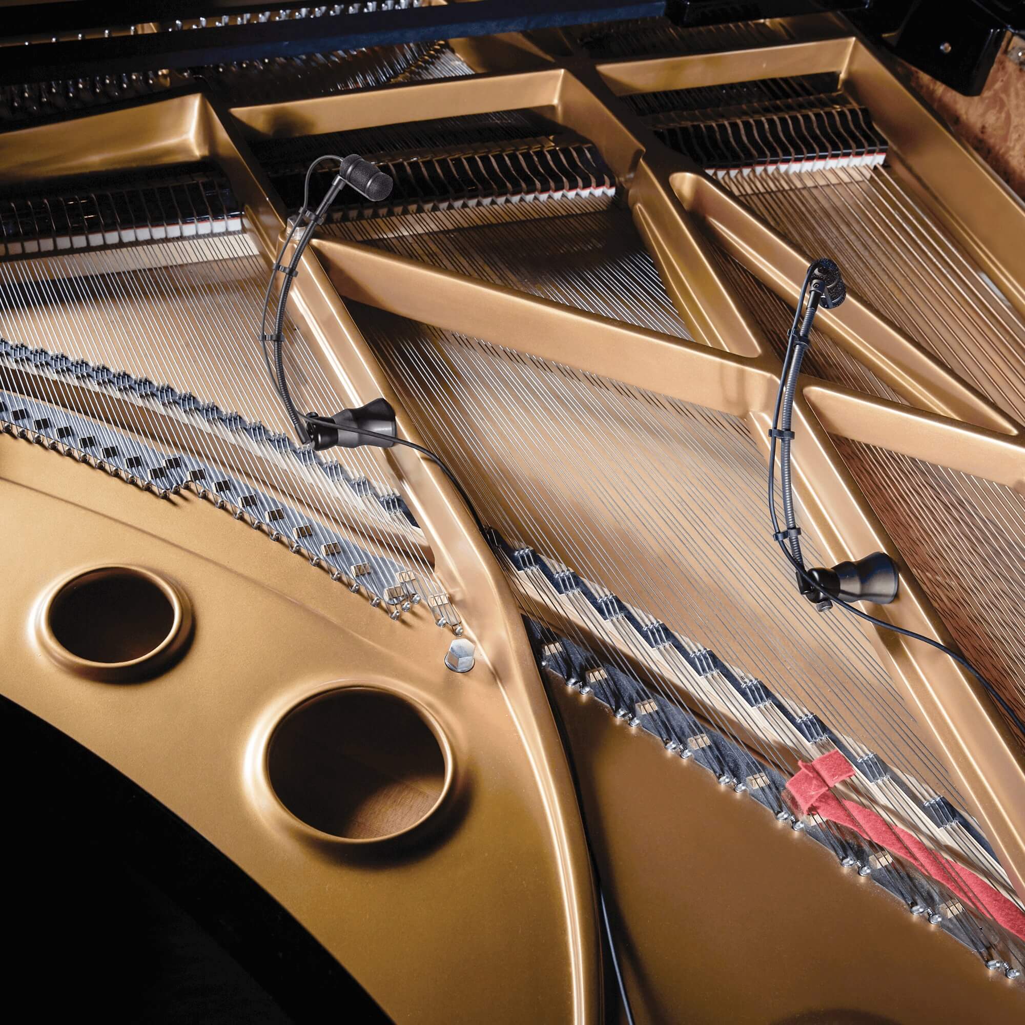 The Audio-Technica ATM350PL Cardioid Condenser Instrument Microphone with Piano Mounting System, inside a grand piano