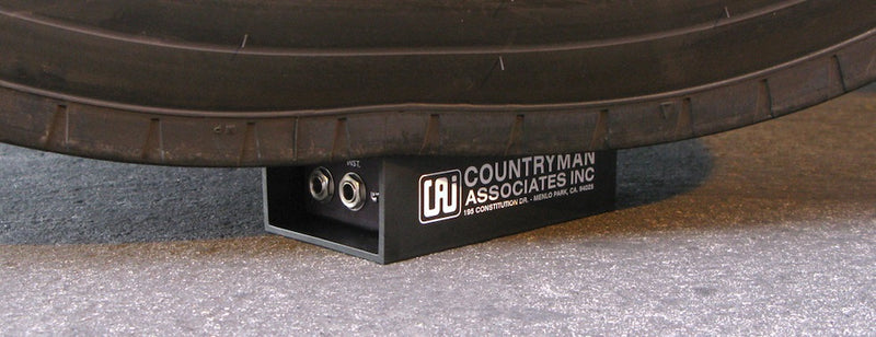 Closeup of a Countryman Direct Box underneath a truck tire