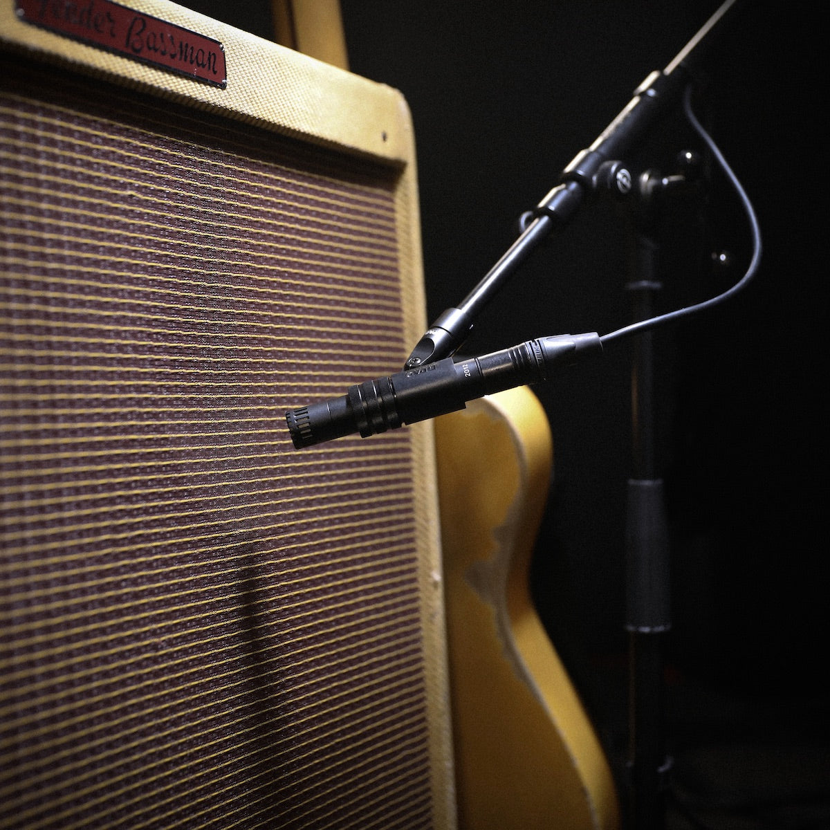 DPA 2012 Compact Cardioid Condenser Microphone, mounted near a guitar amp